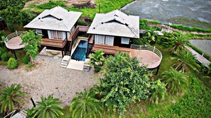 A bungalow with a swimming pool, surrounded by lush greenery and palm trees. - The White House Boutique Chiangrai (Chiang Rai)