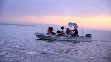 A boat with several people on it, floating on calm water.