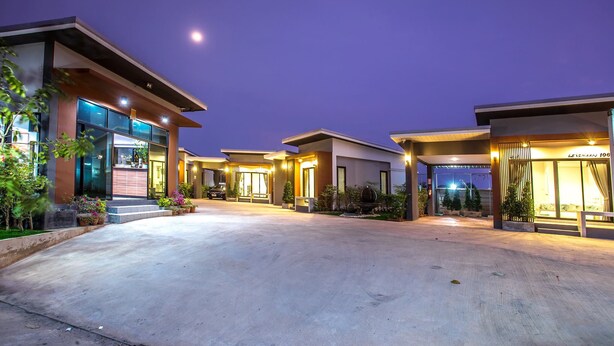 Un hotel moderno con un amplio camino de acceso e ingreso bien iluminado.
