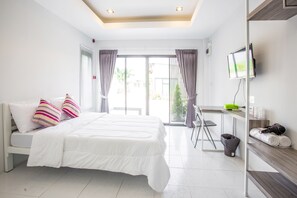 A modern hotel room with a large bed, a desk, and a TV. - Baan Le Vimaan (Nakhon Ratchasima)
