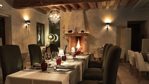 Uma sala de jantar com uma mesa comprida posta para refeição, cercada por cadeiras.