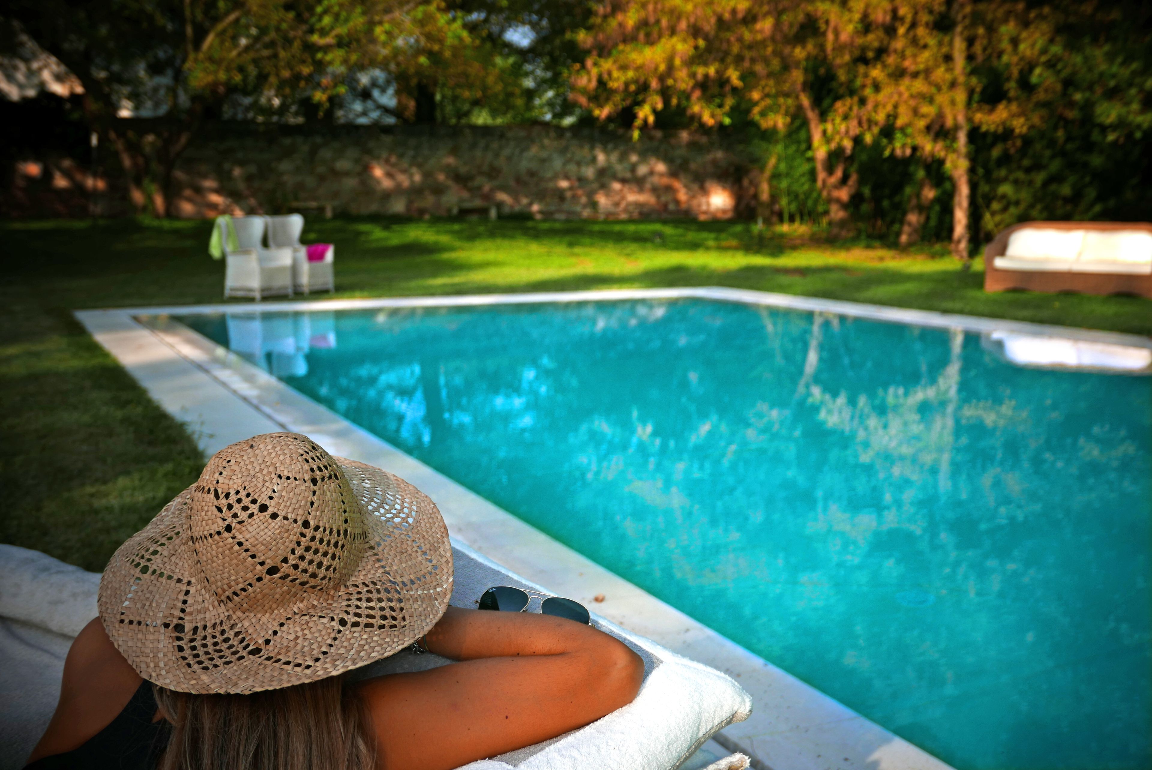 Una piscina al aire libre de temporada, sombrillas