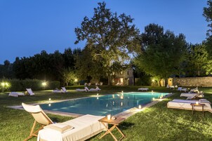 Una piscina al aire libre de temporada, sombrillas