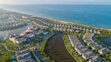 A coastal residential area with houses arranged around a central waterway, connected by roads.