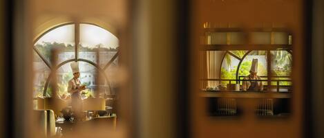 Un restaurante con vistas a un cuerpo de agua y vegetación.