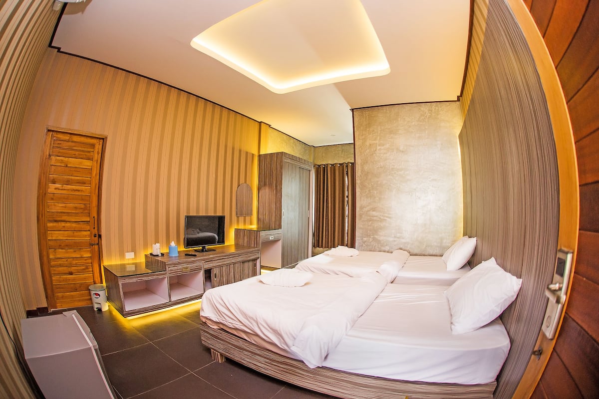 Una habitación de hotel moderna con una cama grande, un televisor, un escritorio y un baño.