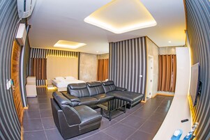 Suíte exclusiva, 1 cama King, para não fumantes, banheira de hidromassagem | Área de estar | TV de tela plana 32 polegadas com canais digitais, TV