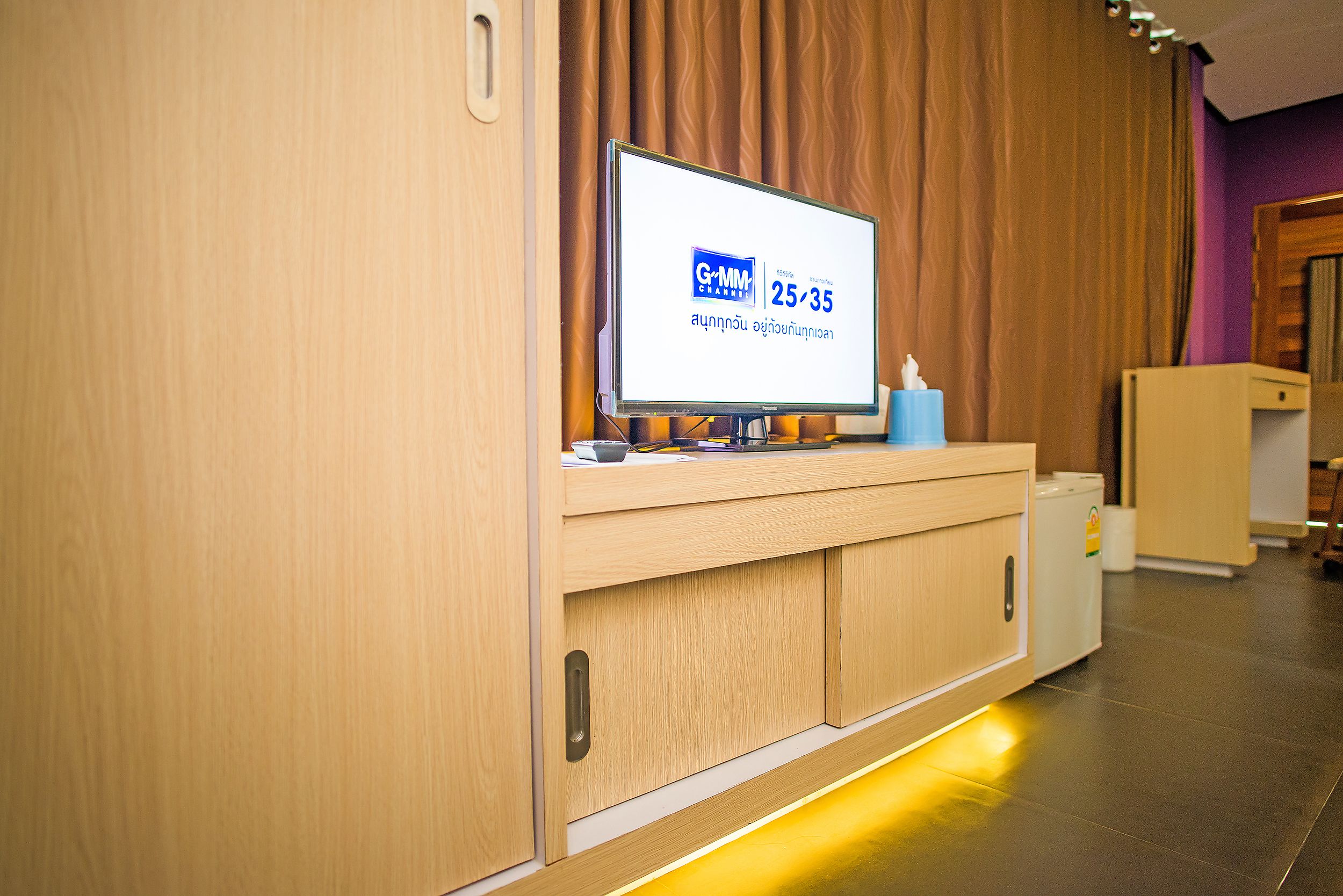 A reception desk with a television displaying a channel logo and time.