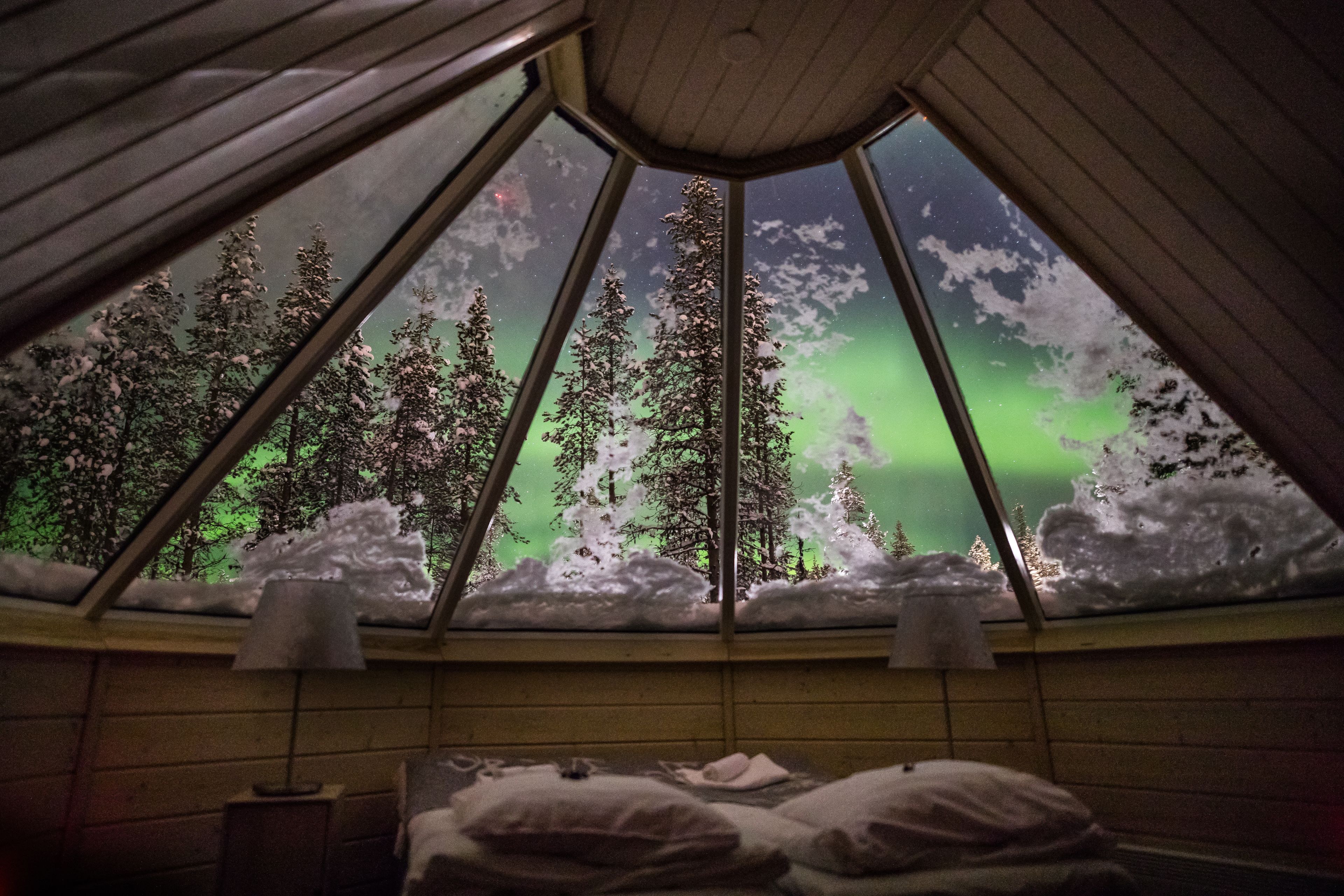 Ein Zimmer mit einem Bett, einem Fenster und einer Lampe.