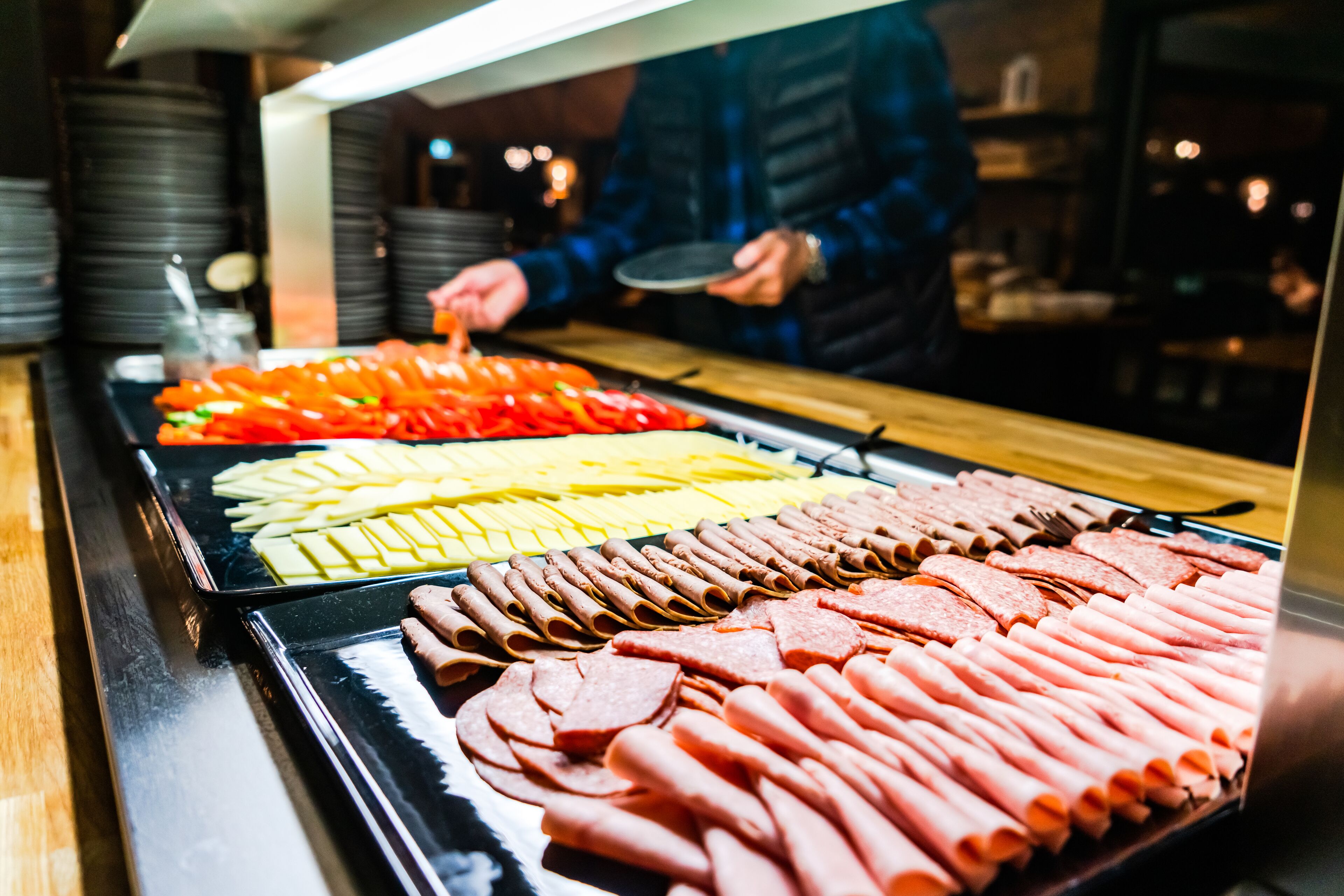 Un buffet proposant une variété de plats, notamment des viandes et des légumes coupés en tranches.
