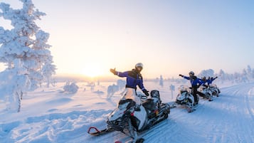 Schneelandschaft mit Schneemobilfahrern.