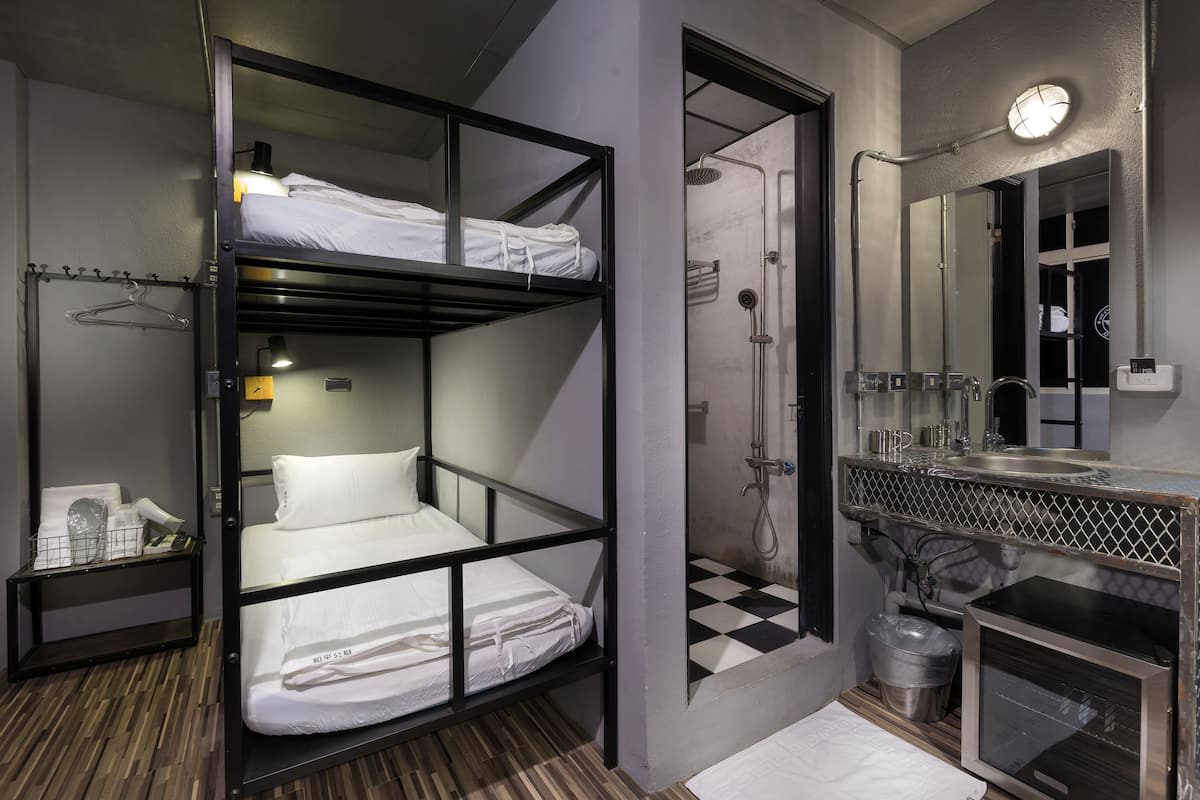 A bunk bed room with a shower, a sink, and a mirror.