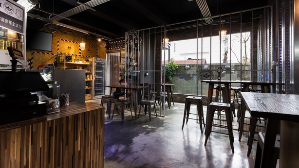 A restaurant interior with a bar area, seating, and a large window offering a view.