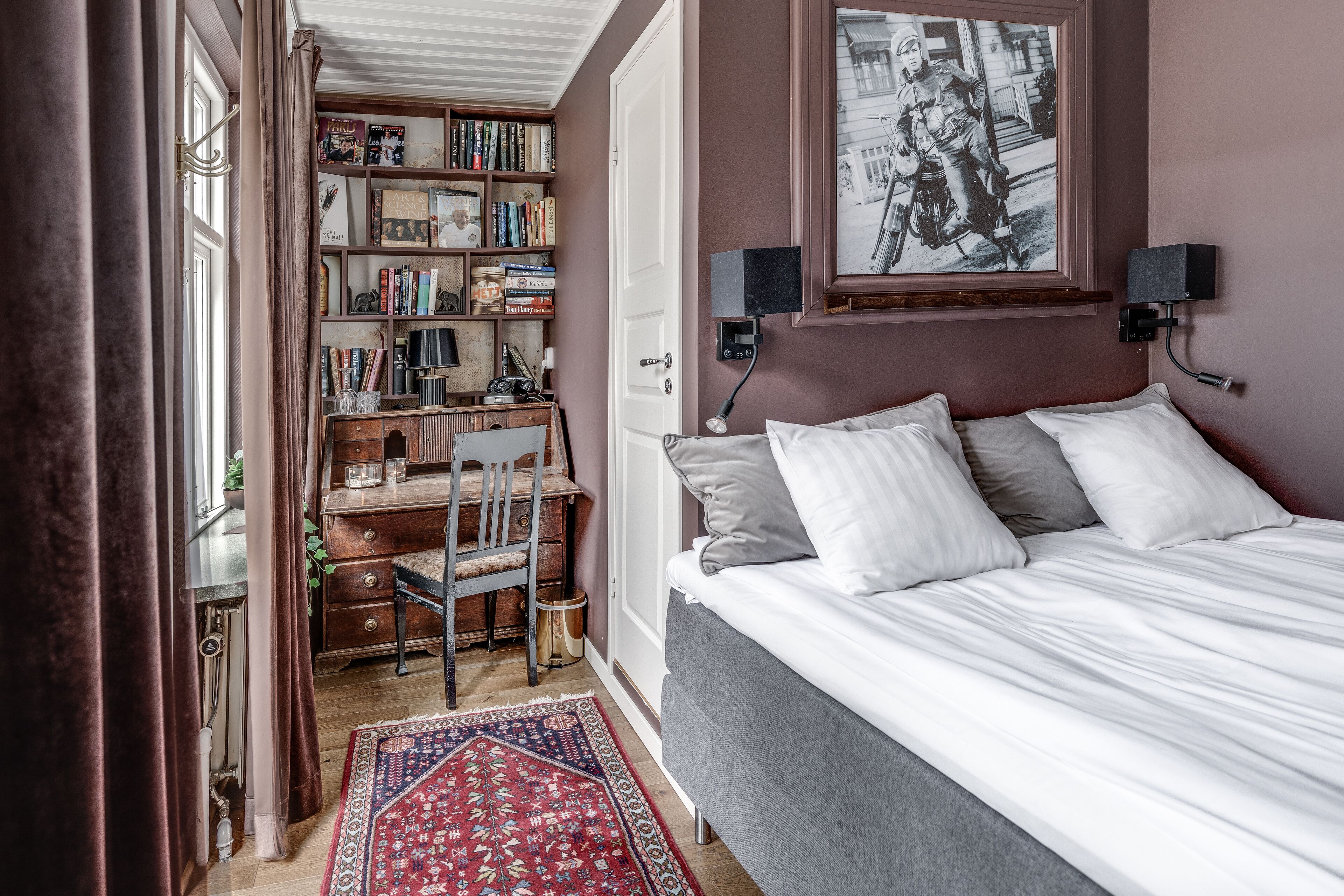 Un dormitorio con una cama, un escritorio y una estantería.
