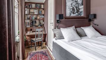Un dormitorio con una cama, un escritorio y una estantería.