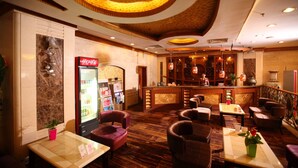 A hotel lobby with a bar area, seating arrangements, and a refrigerator stocked with beverages. - Sanfod Hotel Qingdao (Qingdao)