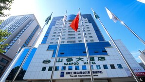 A hotel with a prominent red flag, multiple flags, and a sign indicating it is the Sanfod Hotel. - Sanfod Hotel Qingdao (Qingdao)