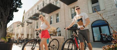 A building with a brick facade, outdoor seating, and a bicycle parked in front.