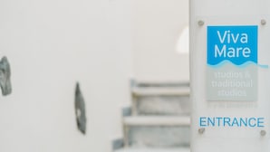 A staircase leading to an entrance with a sign reading "Viva Mare studios & traditional studios" and "ENTRANCE". - Viva Mare Studios (Astypalaia)