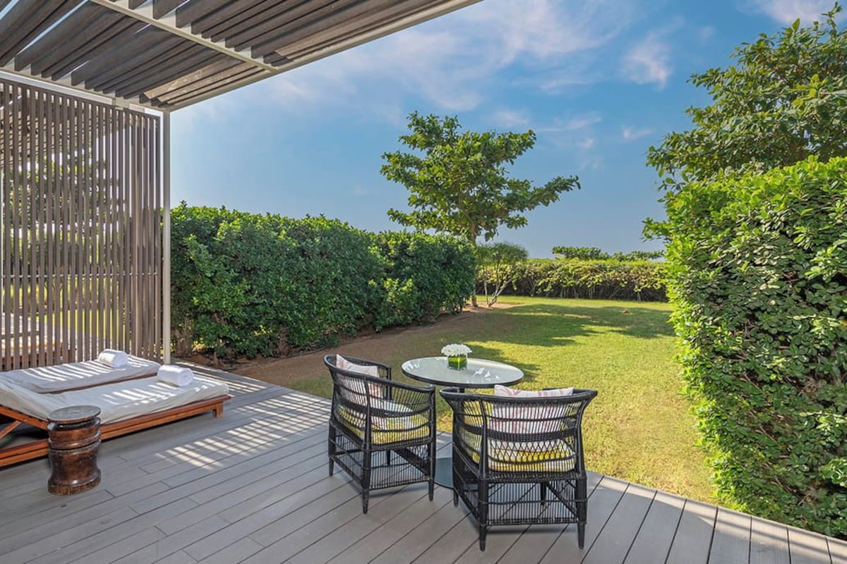A deck with a sofa, two chairs, and a table.