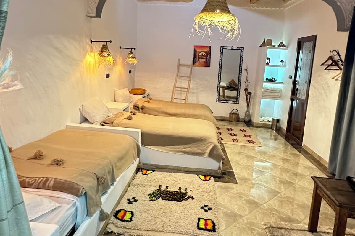 Une chambre à coucher avec un lit, une échelle, un miroir et un luminaire suspendu.