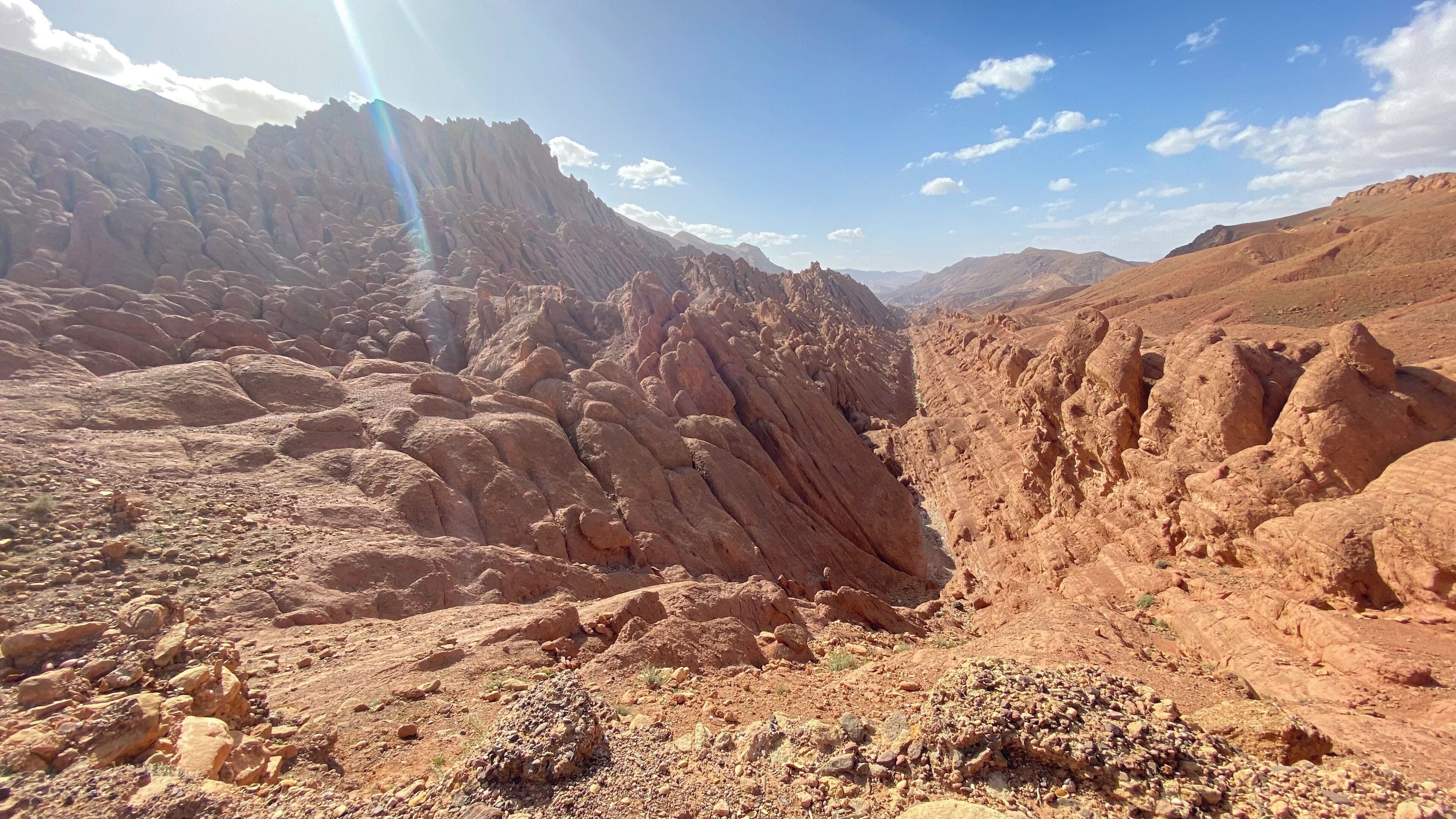 Eine zerklüftete Schluchtlandschaft mit felsigem Gelände und blauem Himmel.