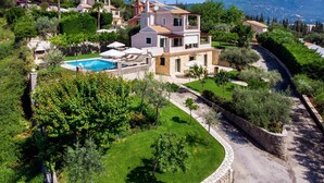 A two-story house with a swimming pool, surrounded by lush greenery and a stone wall. - Il Tesori Dassia Villas (Corfu)