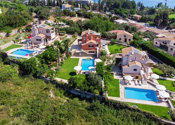 A residential area with multiple houses, a swimming pool, and a well-maintained garden. - Il Tesori Dassia Villas (Corfu)