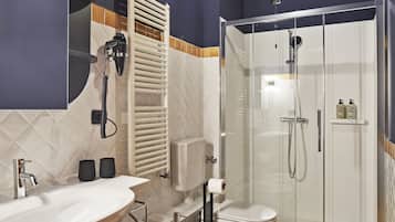 Un baño moderno con lavamanos amplio, inodoro y ducha a ras de suelo.