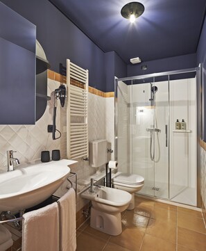 A modern bathroom with a large sink, toilet, and walk-in shower. - Urbanauts Studios Minelli (Trieste)