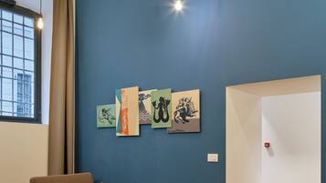Een moderne woonkamer met een blauwe muur, een bank, een salontafel en kunstwerken.