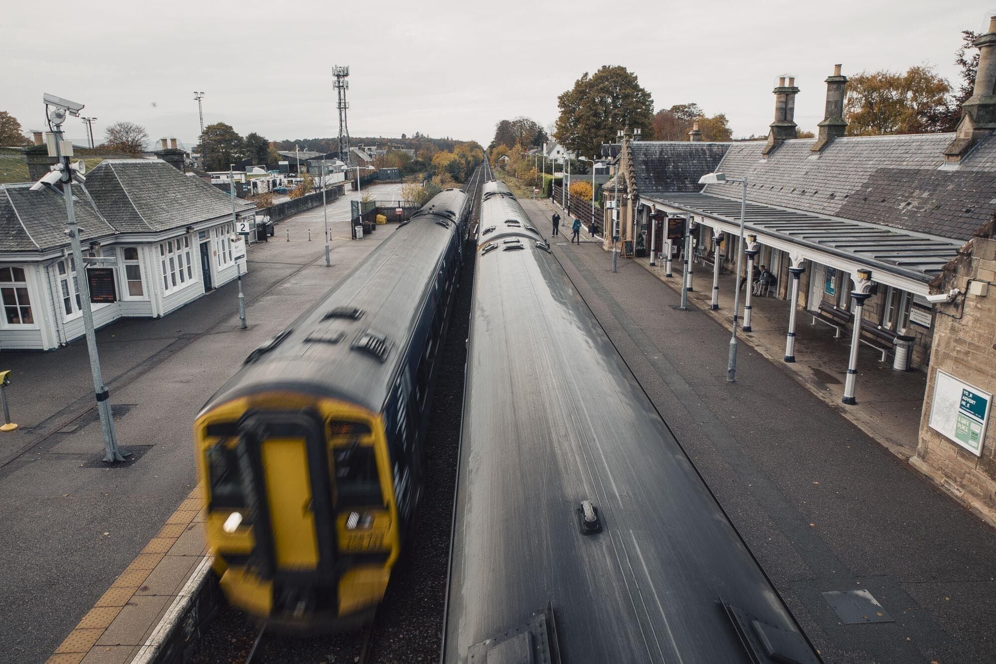 A train station with a long platform, a station building, and a signal box.