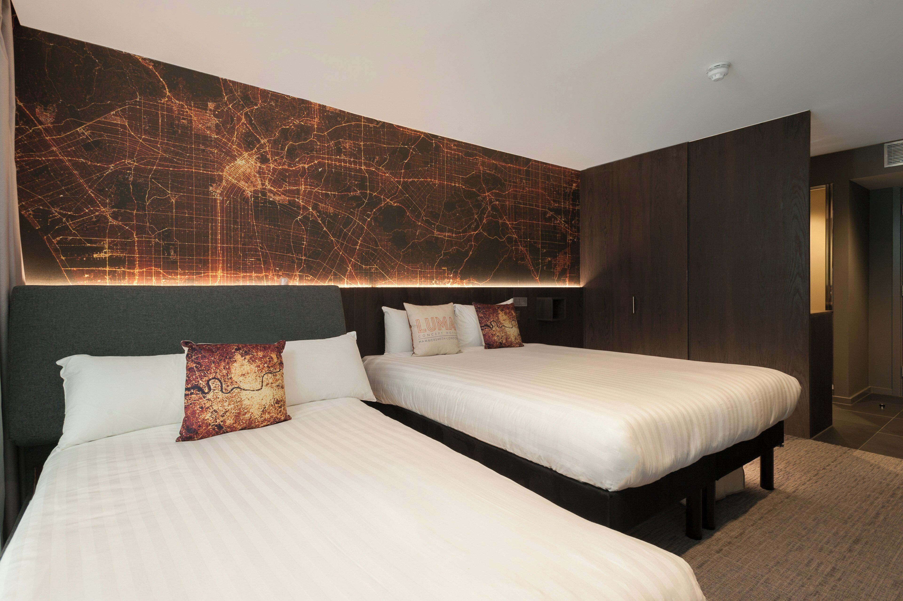 Ein Hotelzimmer mit zwei Betten, einer großen Wandkarte und einem Kleiderschrank.