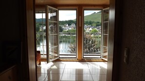 Ein Zimmer mit Blick auf einen See und Häuser am gegenüberliegenden Ufer.