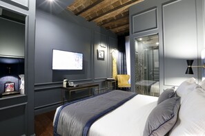 A modern hotel room with a large bed, a desk, a TV, and a bathroom visible through a glass door. - Saint B Boutique Hotel STB (Rome)