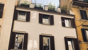 A building with a white facade, multiple windows with dark shutters, and a ground-floor shop named 'EDEN CAFFÈ BARBERINI'. - Saint B Boutique Hotel STB (Rome)
