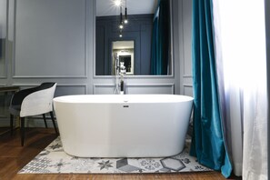 A modern bathroom with a freestanding bathtub, a mirror, and a chair. - Saint B Boutique Hotel STB (Rome)