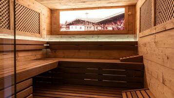Eine Holzsauna mit Bänken und einem Fenster mit Blick auf ein traditionelles Gebäude.