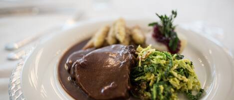 A plate of food with a meat dish, mashed potatoes, and greens.