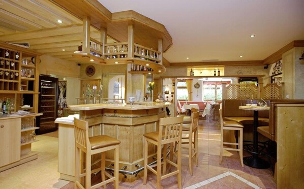 A spacious bar area with wooden furnishings and a mezzanine level. - Das Walzl (Lans)