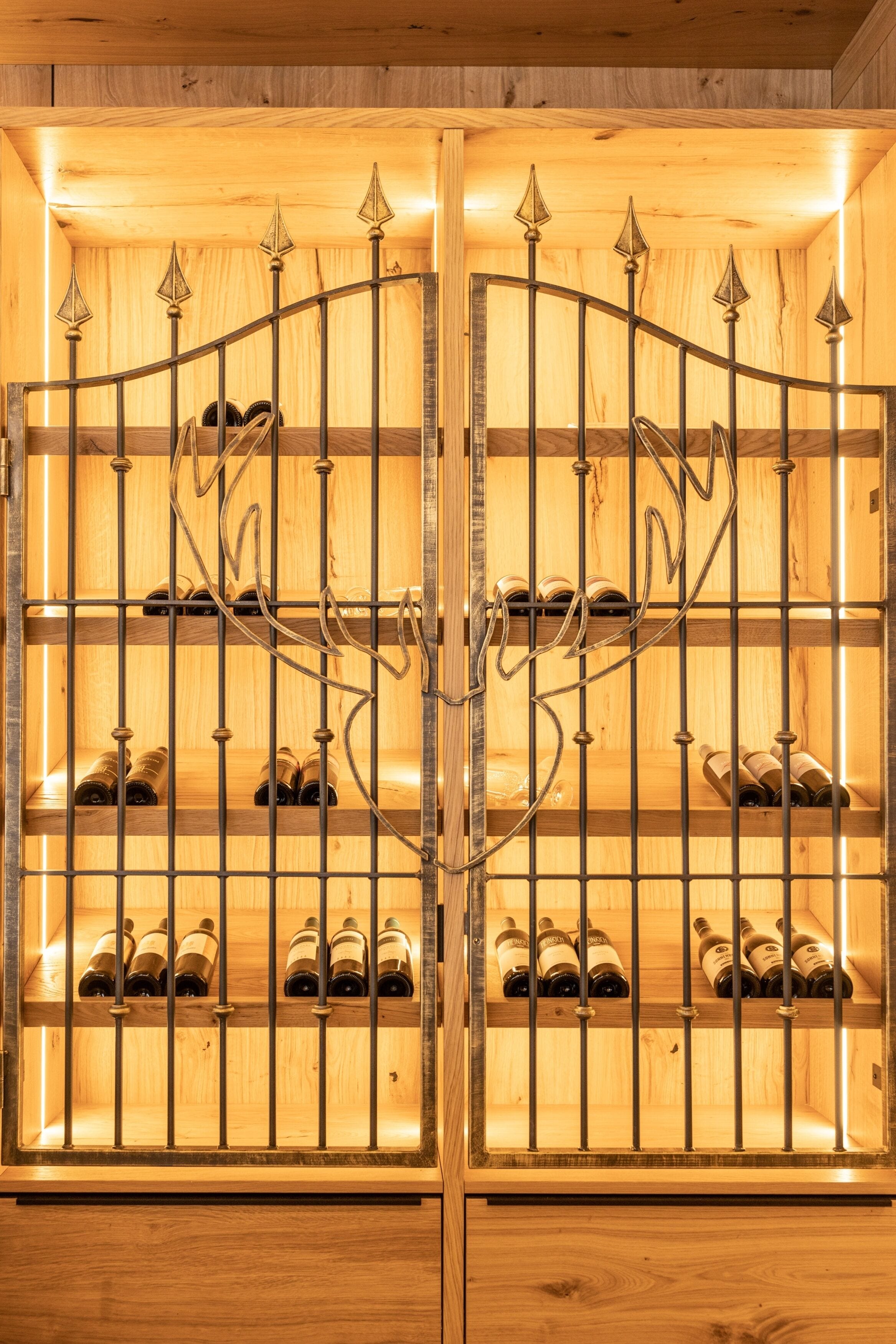 A wine cellar with wooden shelves and metal racks holding wine bottles.