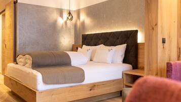 A modern bedroom with a wooden bed frame, a tufted headboard, and a bedside table.