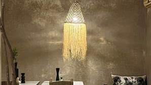 A modern room with a dining area, a bed, and a hanging light fixture. - RIAD NAFORA  (Marrakech)