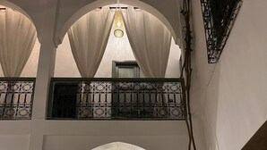 A courtyard with a central door, arches, and a hanging light fixture. - RIAD NAFORA  (Marrakech)
