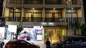 A multi-story hotel with balconies, a visible entrance, and a sign for 'Grand Suites Hotel'. - Grand Suites Hotel (Beirut)