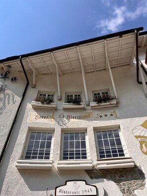 Een gebouw met een bord waarop 'Hotel La Meridiana' en 'Ristorante 1945' staat, wat een restaurant aangeeft.