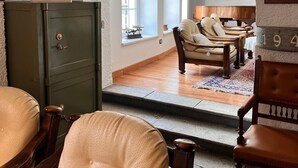 A room with a fireplace, a dining area, and a view through an arched doorway. - La Meridiana (Madesimo)