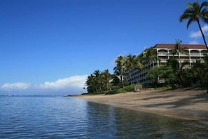 A beachfront hotel with a red roof, multiple balconies, and palm trees. - Lahaina Shores #532 Studio Bedroom Condo by RedAwning (Lahaina)