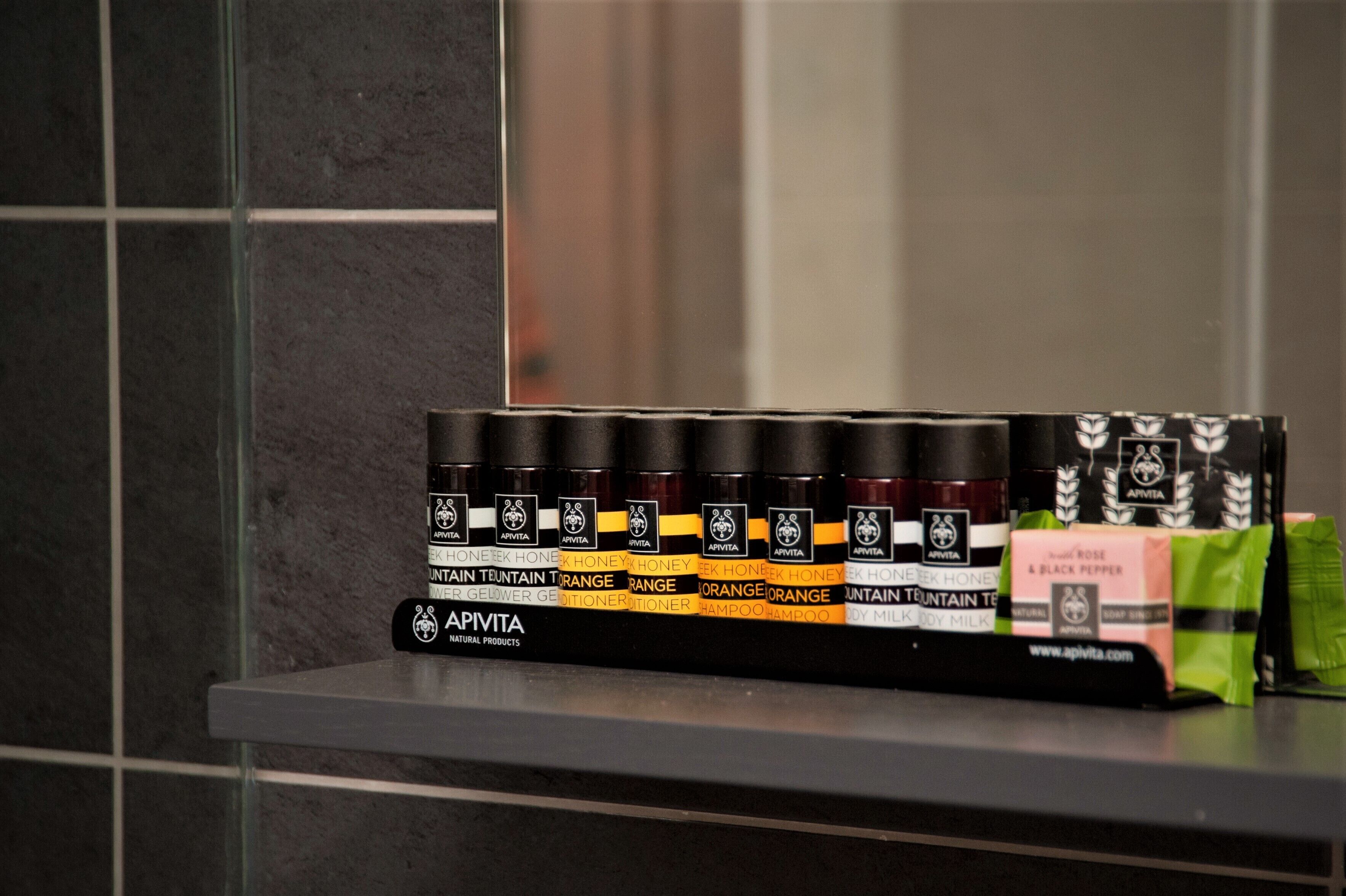 Une rangée de produits de soins capillaires Apivita est exposée sur une étagère.