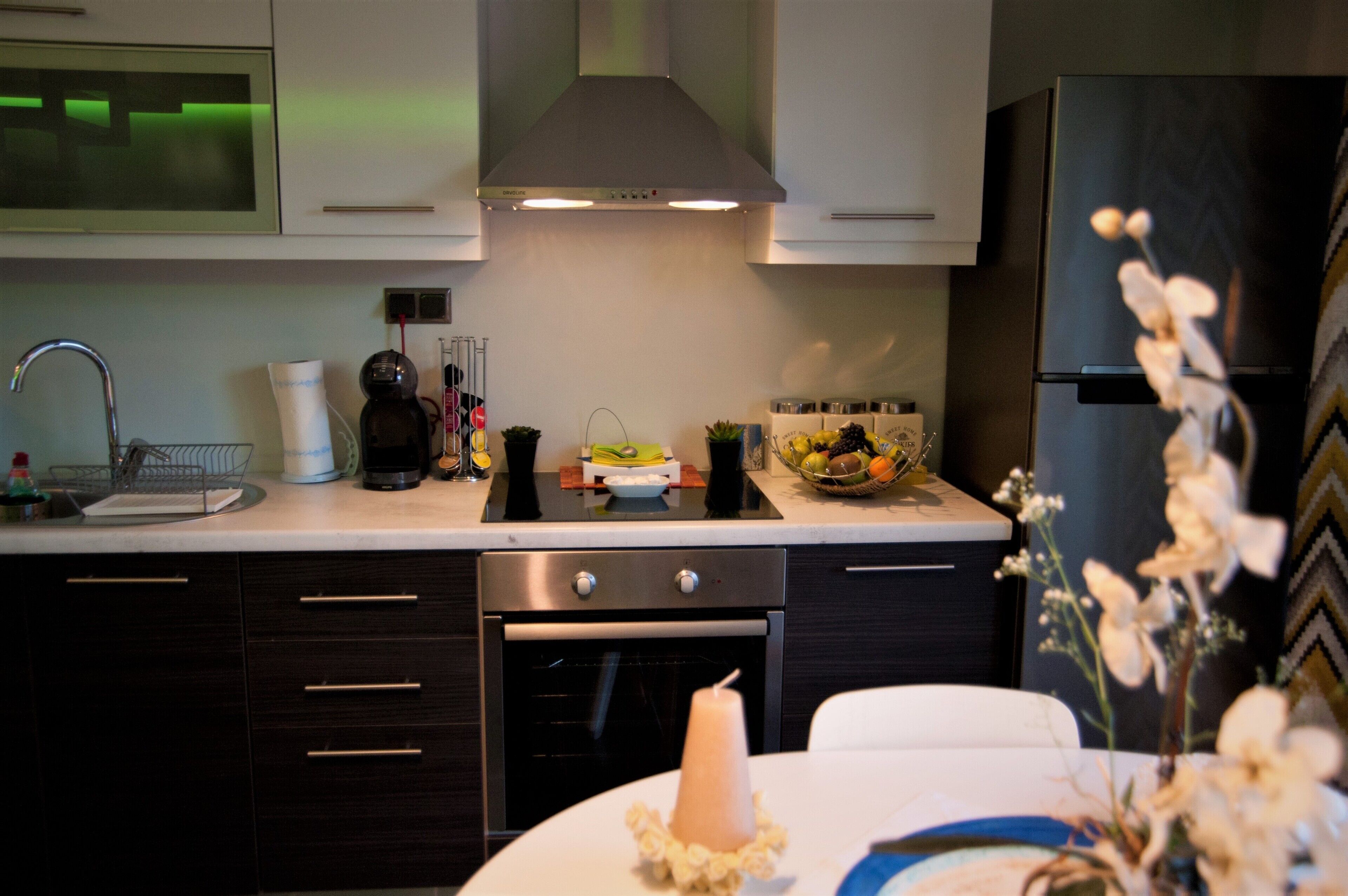 A modern kitchen with a stove, oven, sink, and a refrigerator.